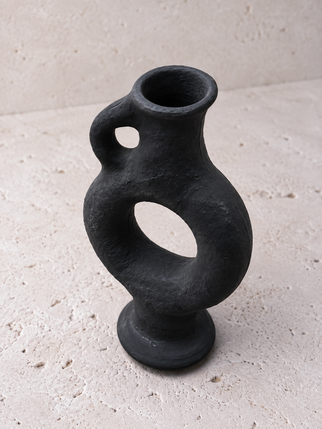 Detalle de la textura volcánica rugosa del jarrón Obsidian negro mate