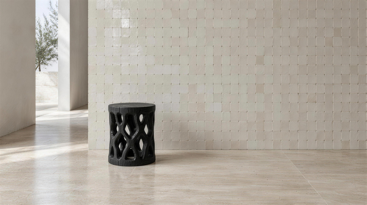 Ivory zellige wall with a carved black stool